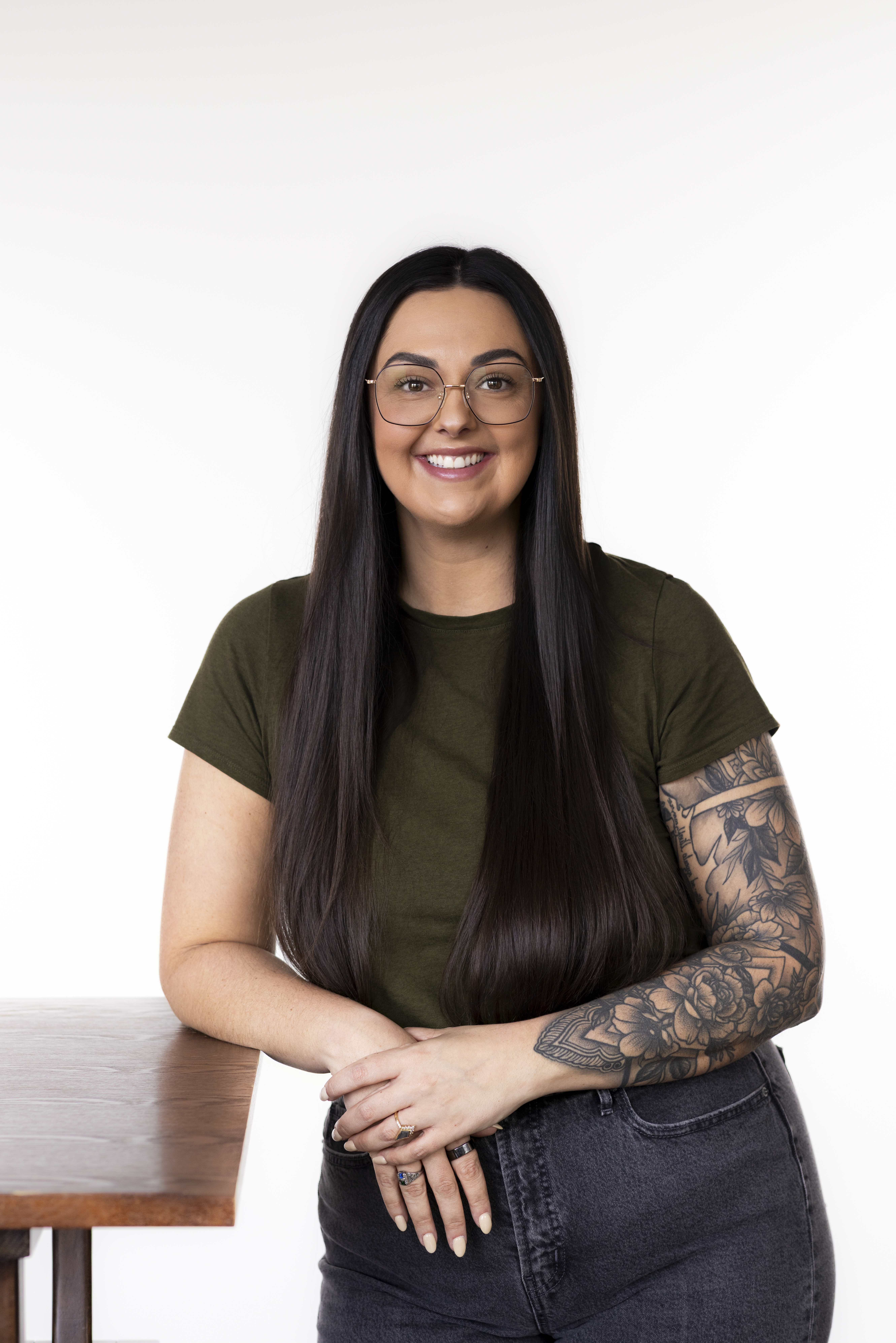 Portrait of a therapist leaning on a desk and smiling
